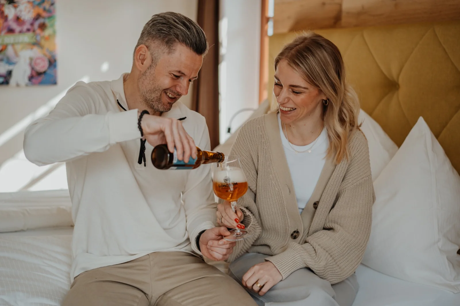 Ein Paar genießt ein LONCIUM Bier im Hotelzimmer