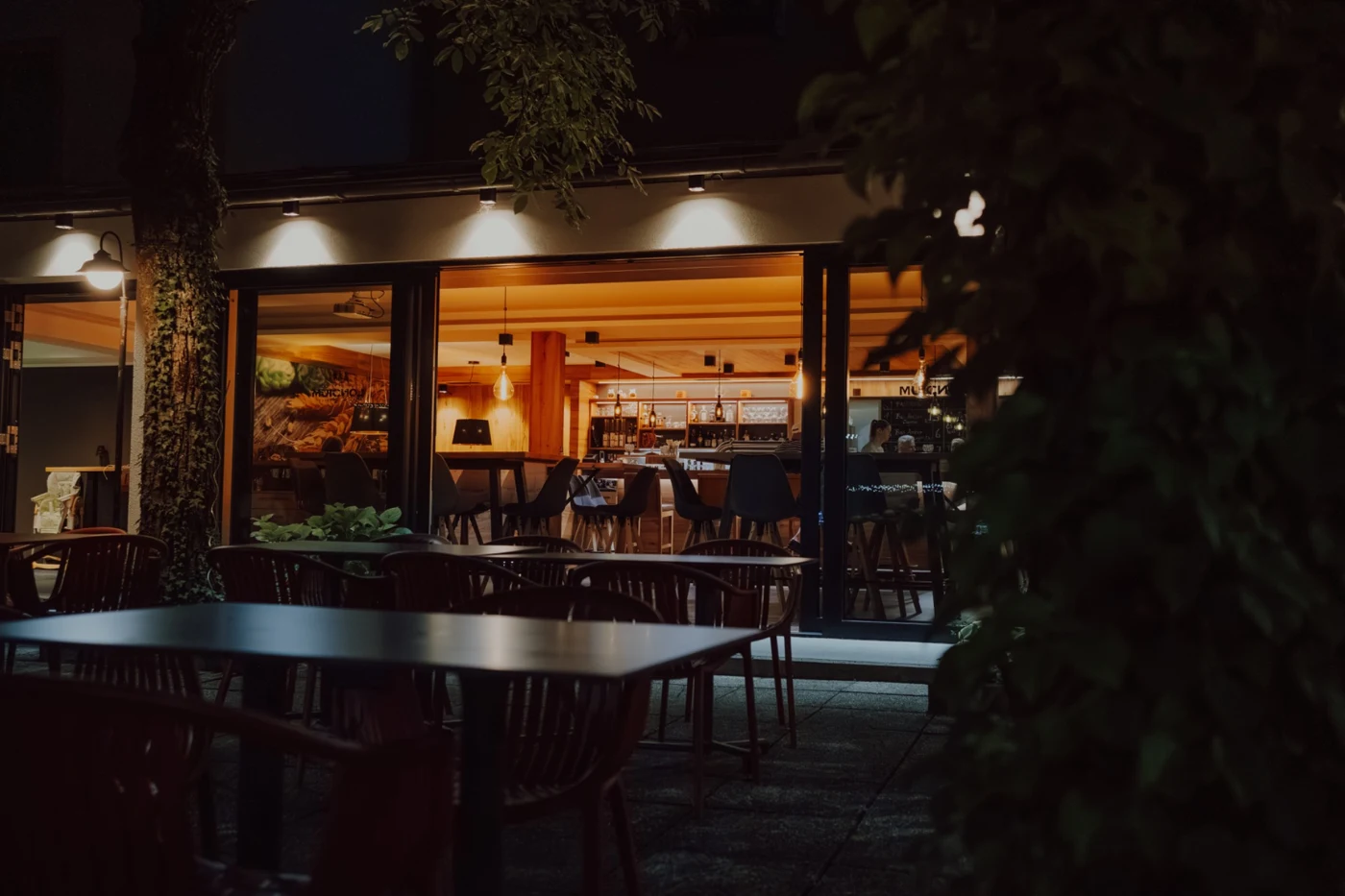 LONCIUM Biergarten am Abend mit Blick in die beleuchtete Bar
