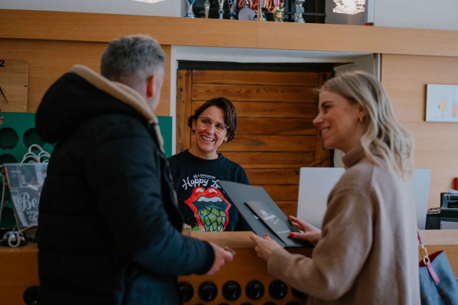 Gäste werden an der hölzernen Rezeption des Bierhotels begrüßt