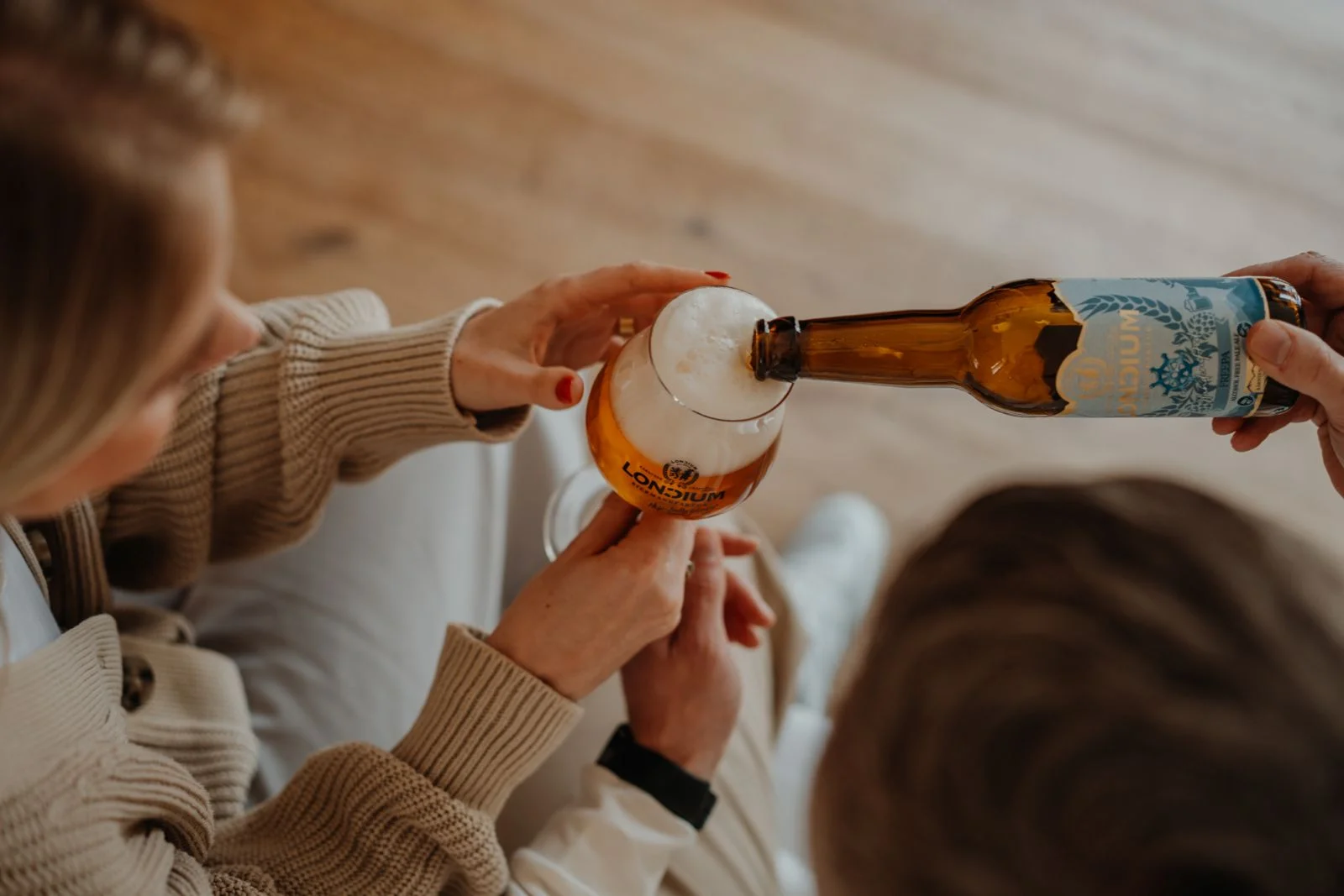 FREEPA wird aus der blauen Flasche in ein LONCIUM Bierglas eingeschenkt